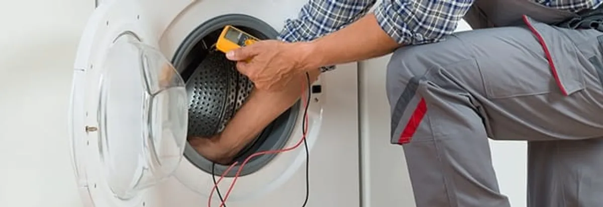 Dryer repair technician inspecting and repairing a clothes dryer in Jersey City, NJ