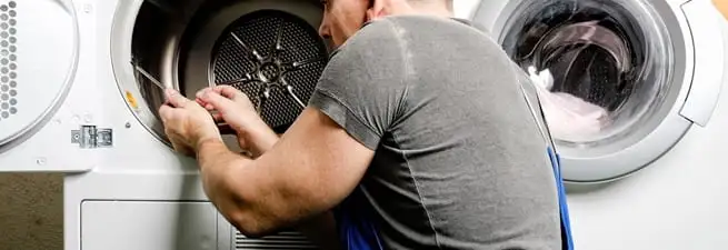 Dryer repair technician fixing a clothes dryer drum in Jersey City, NJ