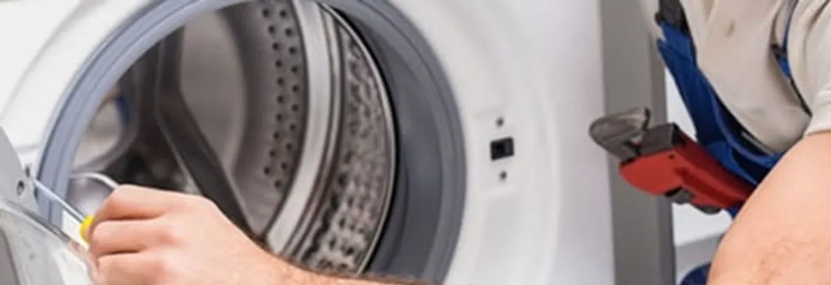 Appliance technician repairing a clothes dryer drum and internal parts in Jersey City, NJ