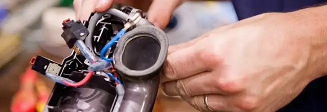 Vacuum repair technician reconnecting wiring and components in Jersey City, NJ