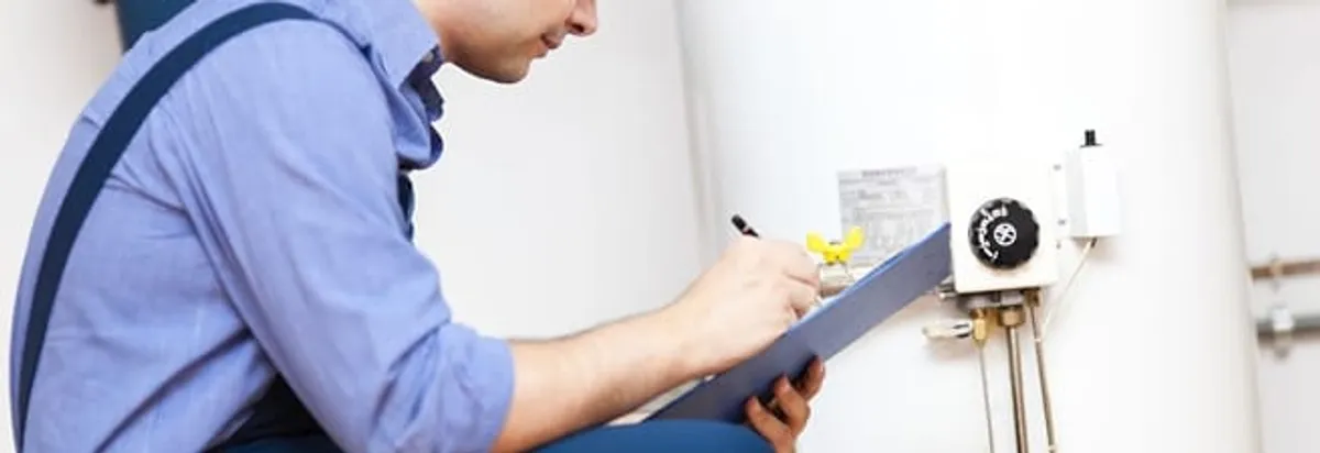 Water heater repair technician inspecting the unit and recording service notes in Jersey City, NJ